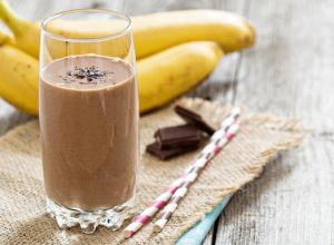 Chocolata banana smoothie in a glass with straws
